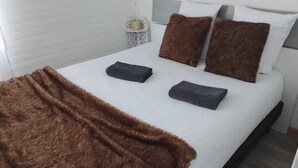 A bed with a brown blanket, two pillows, and a folded blanket on the bed. - Chalet-type house for 7 people with swimming pool near Disneyland Paris (EuroDisney) (Villiers-sur-Morin)
