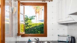 Eine Küche mit Fenster, Spüle, Toaster und Wasserkocher.