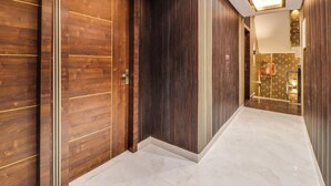 Un couloir avec des portes en bois et un plafond au design moderne.