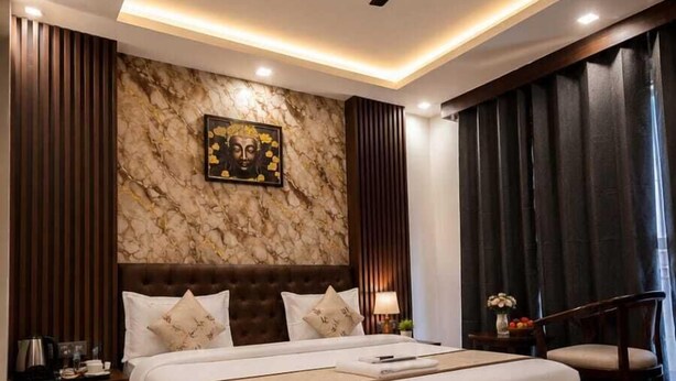Une chambre moderne avec un grand lit, un ventilateur de plafond et un mur en marbre.