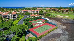Un complejo turístico con varias edificaciones, canchas de tenis y un campo de golf.
