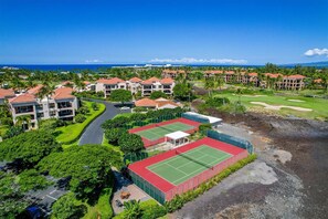 Ein Resort mit mehreren Gebäuden, Tennisplätzen und einem Golfplatz.