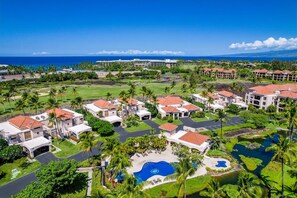 Ein Resort mit mehreren Gebäuden, einem zentralen Pool und Blick aufs Meer.