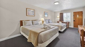 A hotel room with two beds, a desk, and a chair. - Eagle Motel Suite 106 (Manitou Springs)