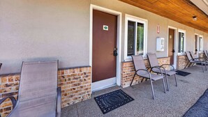 A building with a brown door, a window, and a sign on the wall. - Eagle Motel Suite 106 (Manitou Springs)