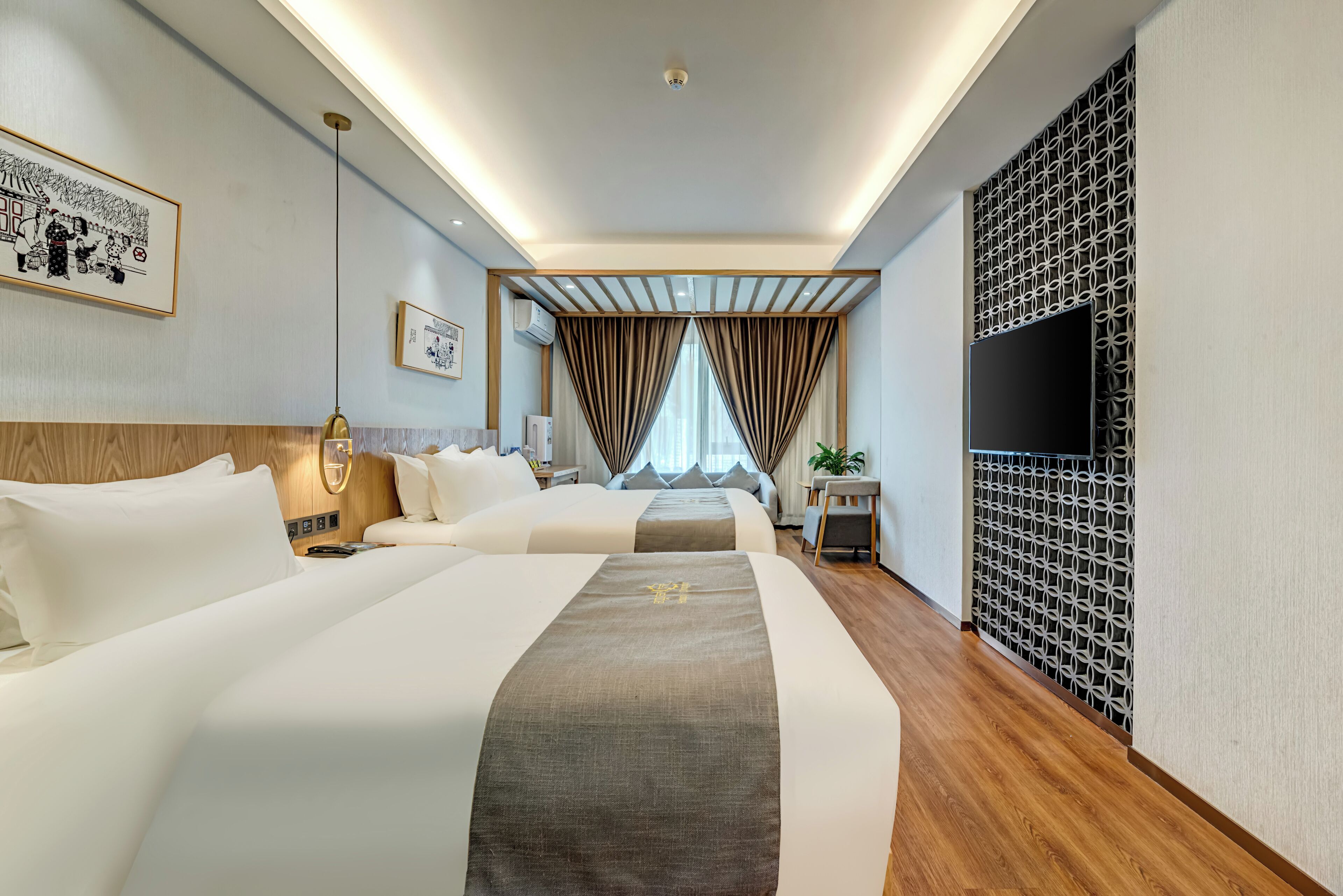 Habitación de hotel con dos camas, televisión, escritorio y aire acondicionado instalado en la pared.