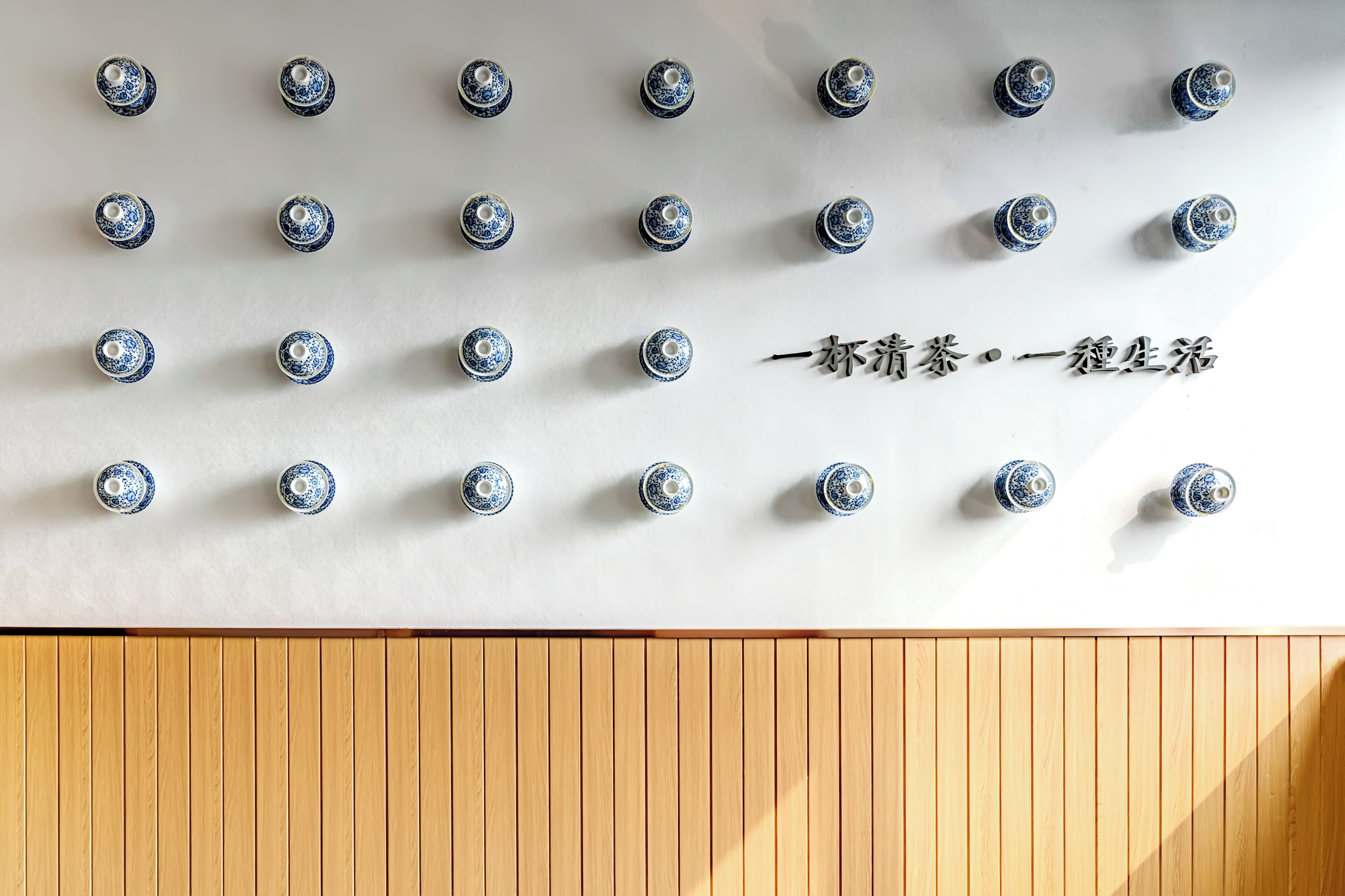 Un mur orné de plusieurs luminaires fixés au mur, disposés selon un motif en grille.
