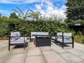 An outdoor patio with a table and chairs, surrounded by lush greenery. - Cross Winds (Lancaster)