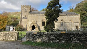 A historic church with a stone facade, a flag, and a sign indicating parking restrictions. - Cross Winds (Lancaster)