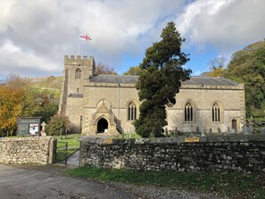 A historic church with a stone facade, a flag, and a sign indicating parking restrictions. - Cross Winds (Lancaster)