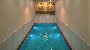 Una piscina interior estrecha con una zona de recepción en la planta superior.