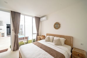Ein Hotelzimmer mit Bett, Schreibtisch, Stuhl und Blick ins Freie.