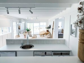 Eine moderne Küche mit eingebautem Geschirrspüler, Spüle und einer Arbeitsplatte mit Bedienfeld.