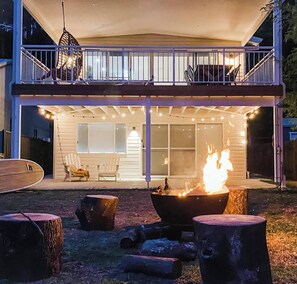 A covered outdoor patio with a fire pit, seating, and a view of the house. - Morgies on Long Beach (Long Beach)