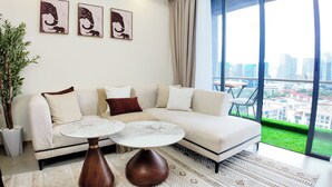 A modern living room with a white sofa, two round coffee tables, and a large window with a city view. - Ikhaya Luxe Westlands with Rooftop Heated pool, gym and amazing GTC view (Nairobi)