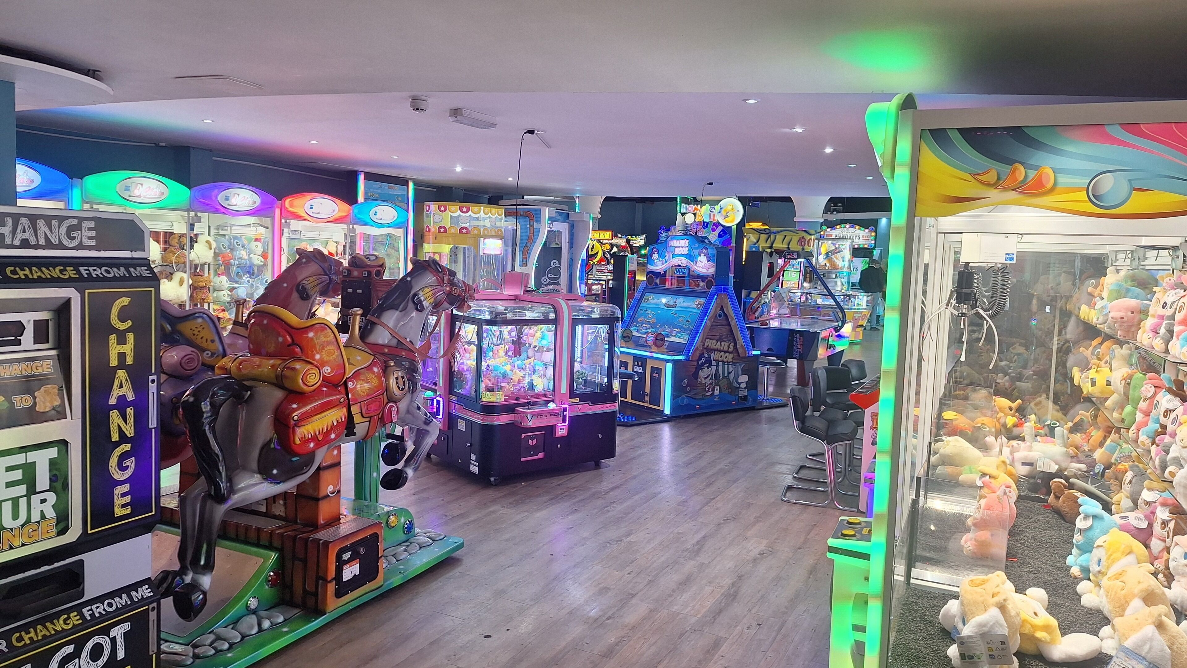 An indoor arcade with various gaming machines and claw machines.