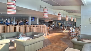 A spacious restaurant with wooden furniture, striped hanging lights, and a visible restroom sign. - MKRJ Camber Sands Caravan- 3 Bedrooms, Sleeps 8, En Suite WC, Dog Friendly, WiFi (Camber)