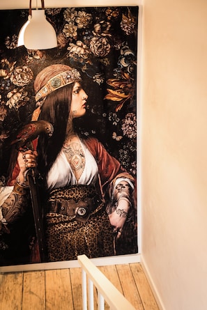 Un mural que muestra a una persona con un pájaro, un cinturón con una medalla y un colgante.