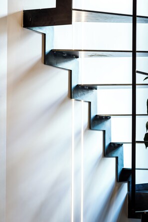 Una escalera moderna con diseño minimalista, caracterizada por líneas limpias y una combinación de materiales blancos y negros.