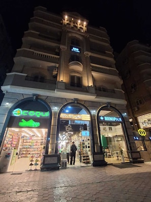 A building with multiple storefronts, including a visible shoe store and a clothing store.