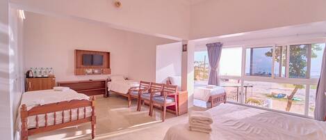 A bedroom with two beds, a TV, a desk, and a chair.