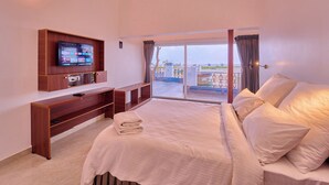 Ein Schlafzimmer mit Bett, einem an der Wand montierten Fernseher, einem Holztisch und einem Balkon mit Blick.