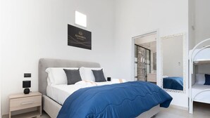 Une chambre à coucher moderne avec un lit, une table de chevet et un miroir.