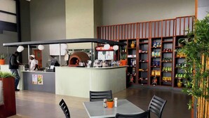 Um restaurante com balcão, área de estar e prateleiras repletas de lanches.