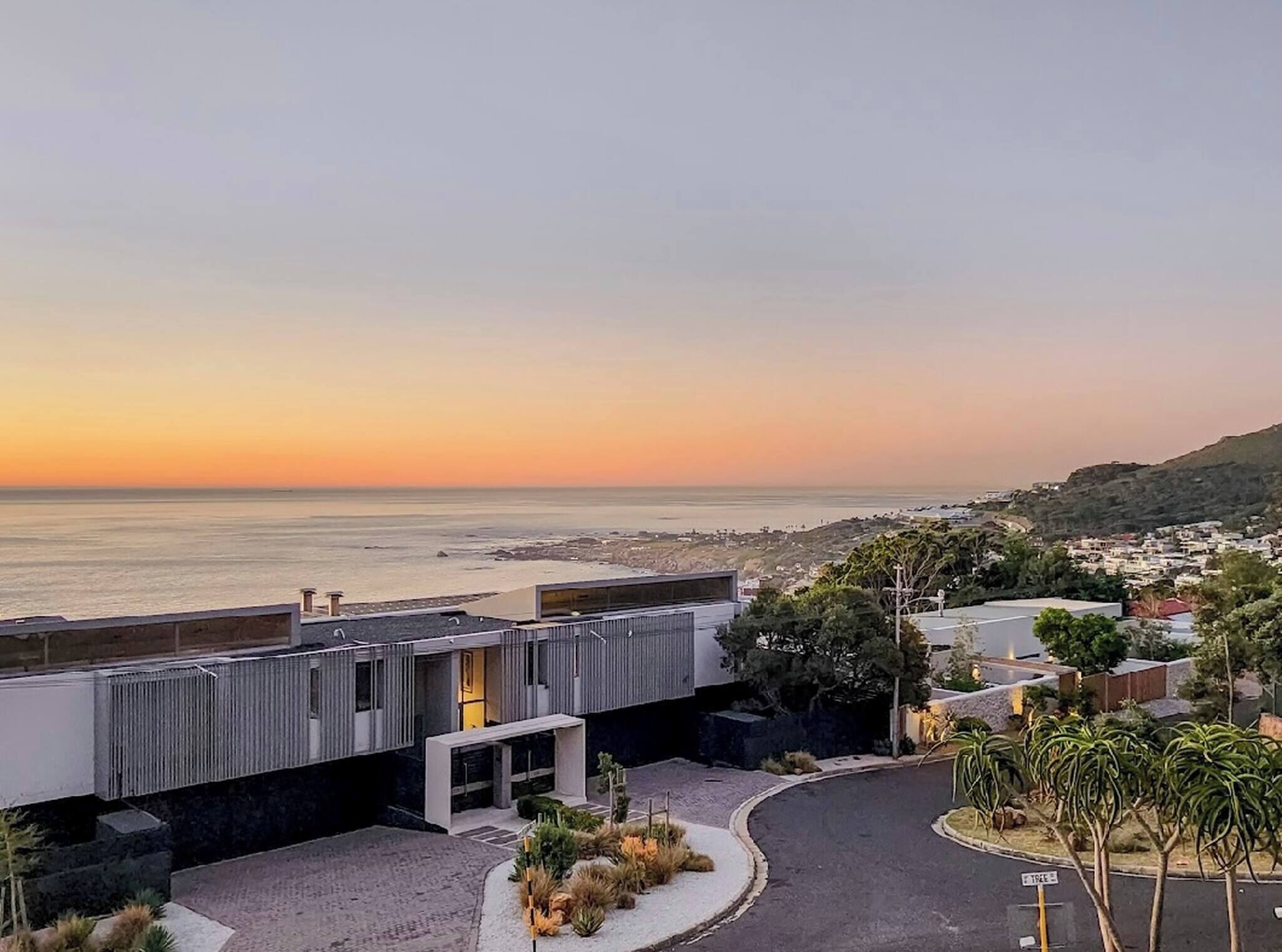 A modern building with a view of the ocean at sunset.