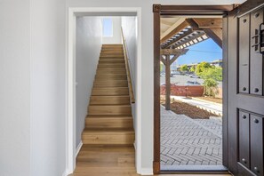 A wooden staircase leading to a door with a view of a parking lot and a building in the background. - Outside Inn - Pacific Grove House - Downtown - Close to Beach (Pacific Grove)