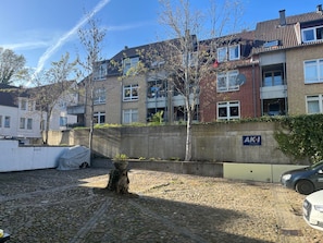 A residential building with a concrete wall, a tree stump, and a parked car. - fewo1846 - Koje Sansibar - fewo1846 - Koje Sansibar / centrally located (Flensburg)