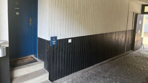 A building entrance with a blue door, a metal gate, and a concrete staircase leading up. - fewo1846 - Koje Sansibar - fewo1846 - Koje Sansibar / centrally located (Flensburg)
