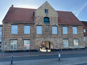 A historic building with a prominent entrance, multiple windows, and a red-tiled roof. - fewo1846 - Koje Sansibar - fewo1846 - Koje Sansibar / centrally located (Flensburg)