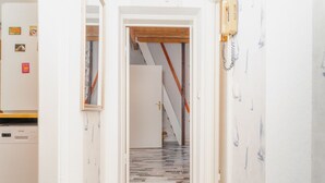 Ein Flur mit einem gemusterten Boden, der zu einer Treppe führt.