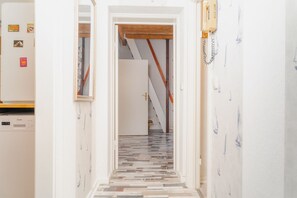 Um corredor com piso estampado que leva a uma escadaria.