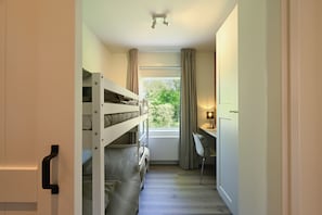 A bunk bed room with a desk and chair, a window with curtains, and a ceiling light. - Enjoy comfort, tranquility and waterside living at Zilt&Zalig on Oranjeplaat. Modern holiday home with private jetty near Lake Veere in Zeeland (Arnemuiden)