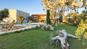 A garden with a pool, a large tree, and a building with a balcony. - Oasis of peace and serenity, nestled in the countryside. (Mesagne)