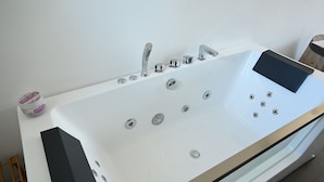 A modern bathroom with a white bathtub, chrome fixtures, and a black control panel. - Oasis of peace and serenity, nestled in the countryside. (Mesagne)