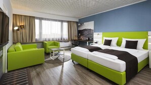 A hotel room with a bed, a desk, a chair, and a television. - Offenburg City by Belvilla- Standard Twin Room (Offenburg)