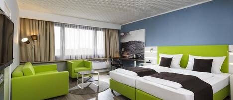 A hotel room with a bed, a desk, a chair, and a television.
