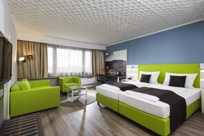 A hotel room with a bed, a desk, a chair, and a television. - Offenburg City by Belvilla- Standard Twin Room (Offenburg)