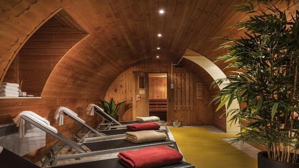 A wooden spa room with a sauna, towels, and a potted plant. - Offenburg City by Belvilla-Family Room (Offenburg)