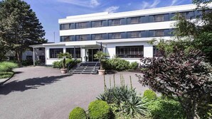 A modern building with a flat roof, multiple windows, and a central entrance with steps. - Offenburg City by Belvilla-Family Room (Offenburg)