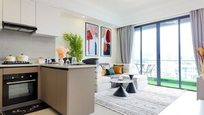 A modern kitchen with a central island, a dining area with a sofa and coffee table, and large windows offering a city view. - Cozy Ikhaya Luxe Silver in Westlands with rooftop gym, heated pool & GTC Views (Nairobi)