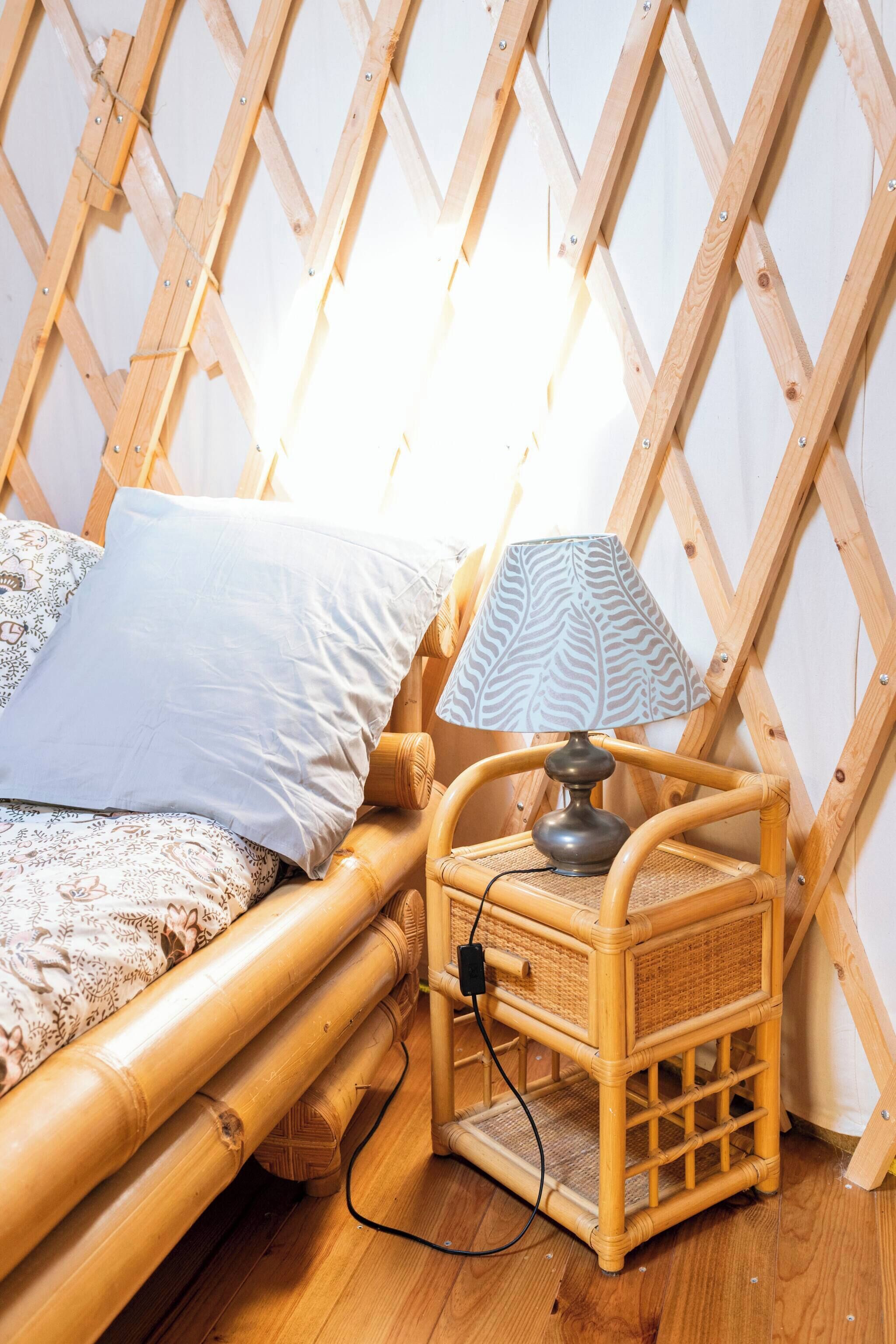 A room with a bed, a lamp, and a wooden lattice wall.