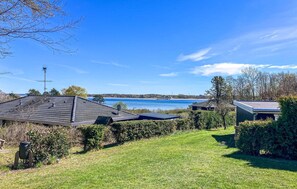 A residential area with a house, a satellite dish, and a view of a lake.