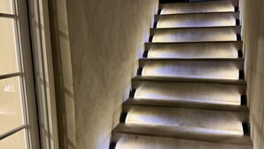 Eine Treppe mit integrierter Beleuchtung, die zu einer Tür mit Glasfenster führt.
