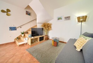 A living room with a TV, sofa, and a staircase. - Vacation home Paola near the beach (Vrbnik)
