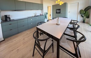 A modern kitchen with teal cabinets, a wooden dining table, and black chairs. - Awesome home in Sydals with WiFi (Sydals)
