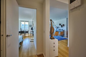 A modern interior with a dining area, a staircase, and a view of the city. - DAUPHINE SQ City island - Elegant Apartment - 1 Bedroom - 1 Bath - Sleeps 2 (Paris)
